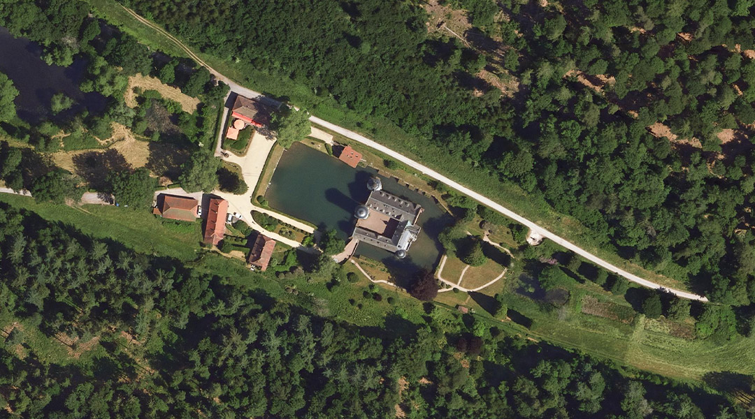 Schloss Mespelbrunn, Mespelbrunn, Digitales Orthophoto 2024 Wasserschloss mit Nebengebäuden umgeben von Wald